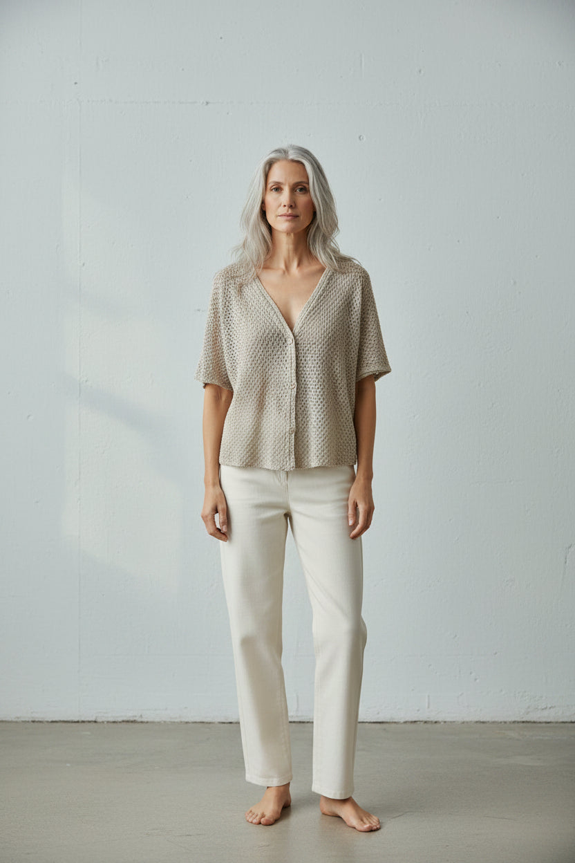 Knitted cardigan on a hanger against a white background