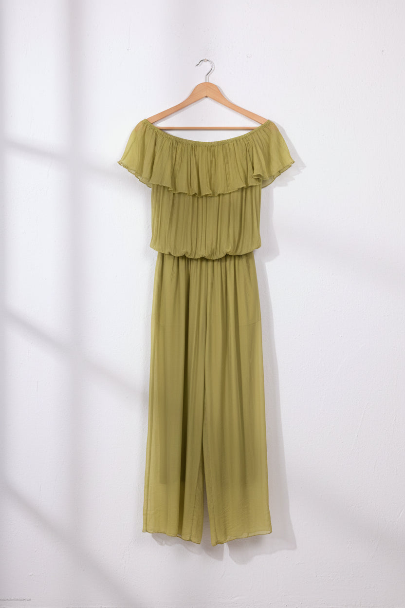 Woman wearing a green off-shoulder top and wide-leg pants on a white background