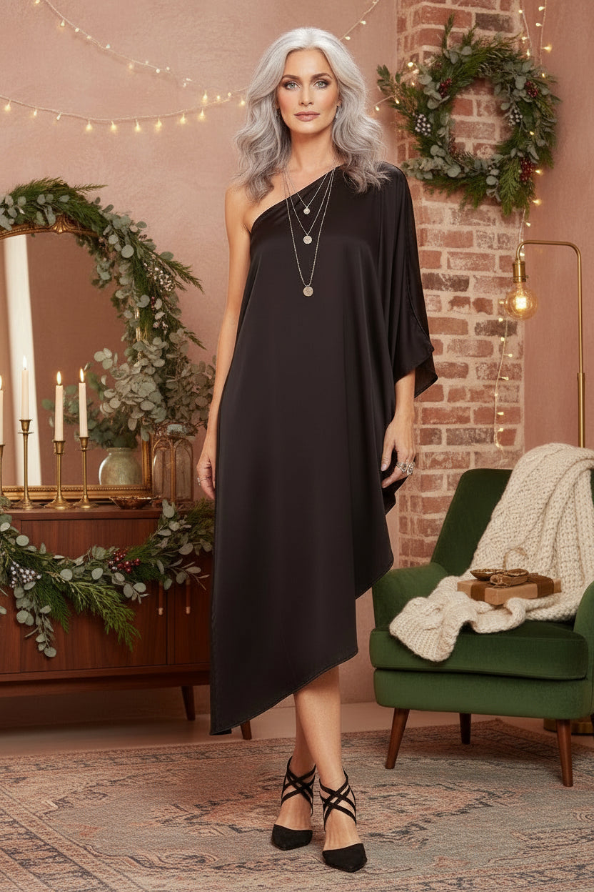 Woman wearing a black one-shoulder dress on a white background