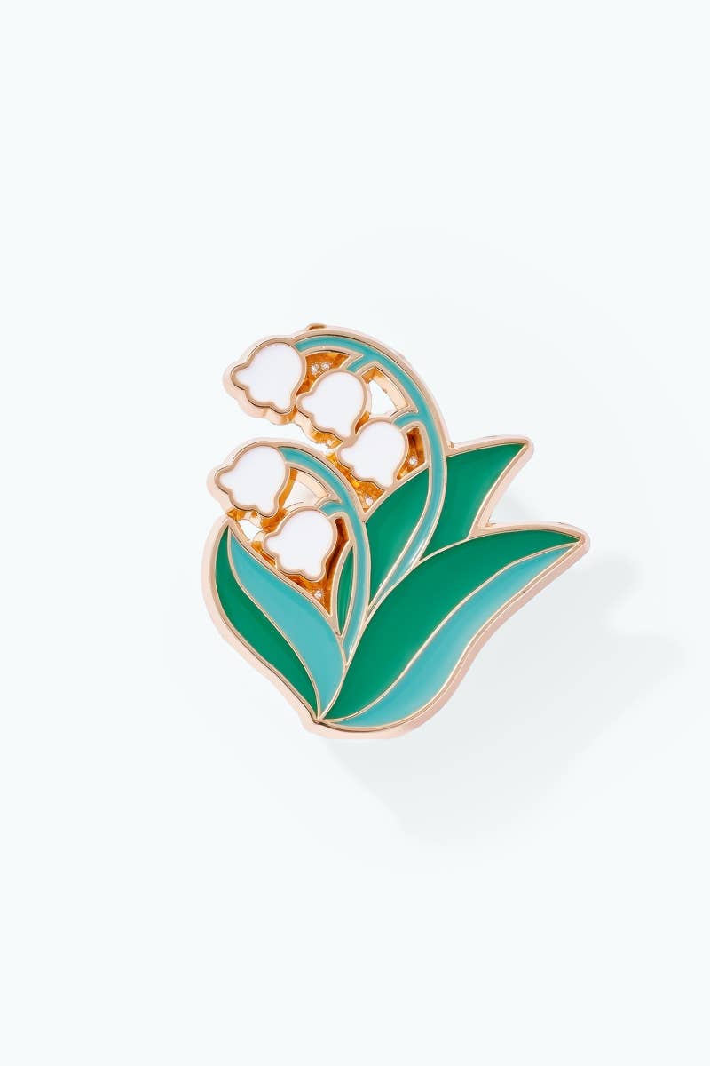 Floral enamel pin with green leaves and white flowers on a white background