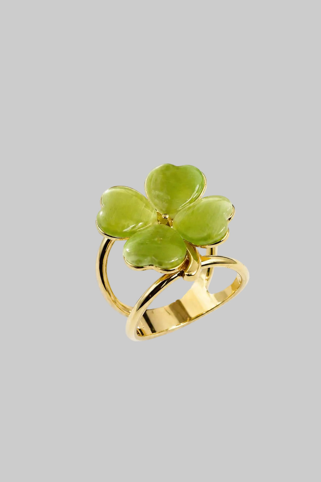Gold ring with a green clover-shaped stone on a white background