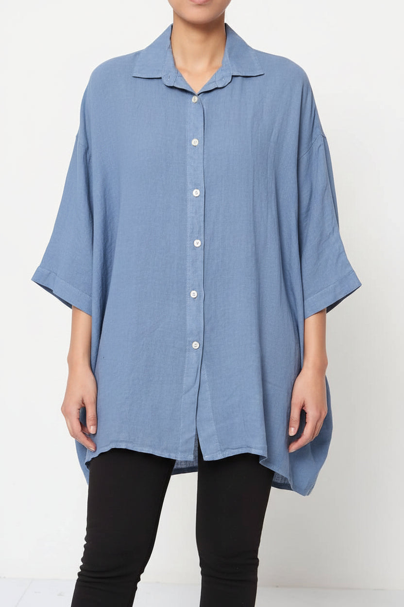 Blue oversized shirt worn by a person on a white background