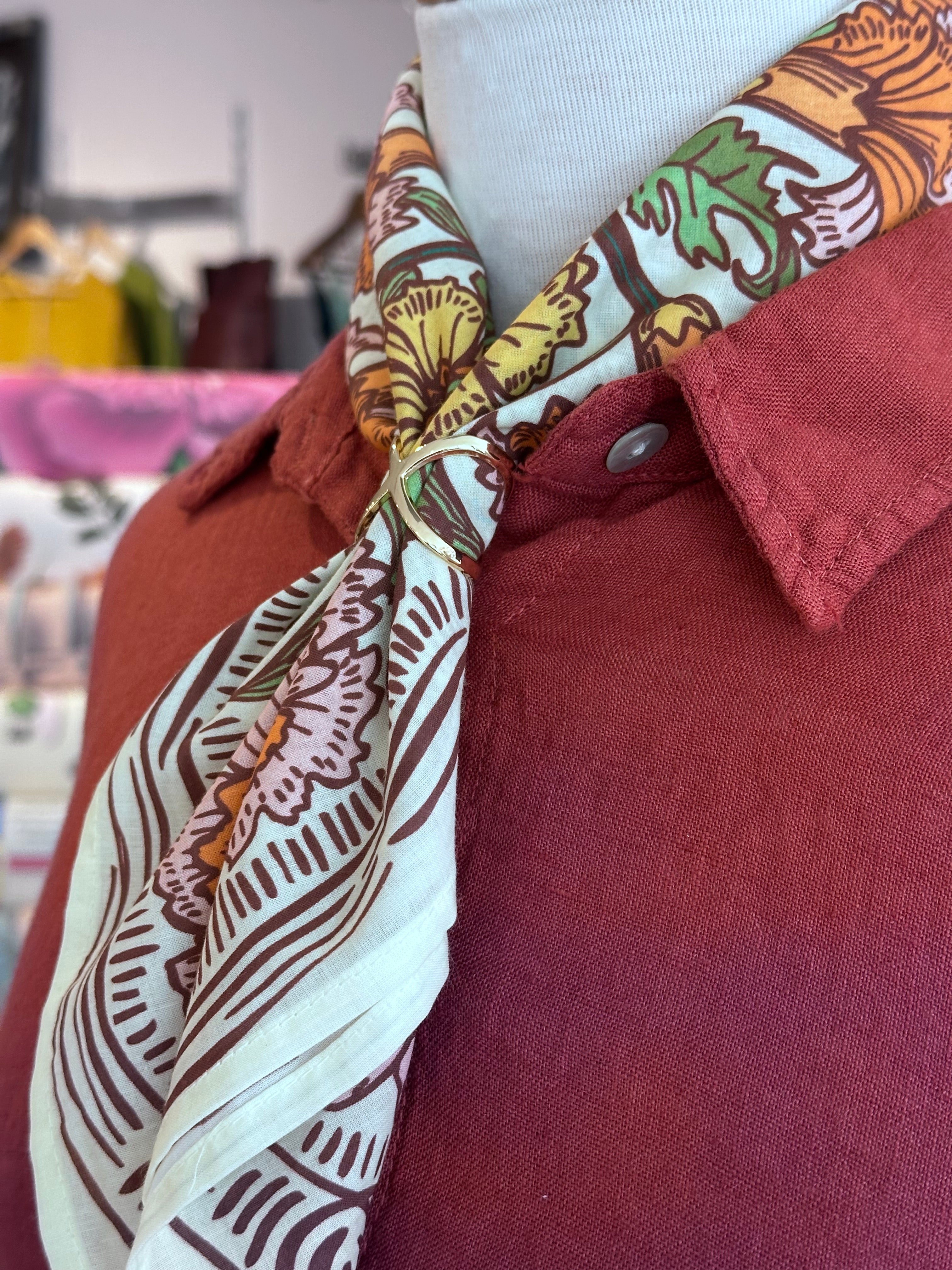 Close-up of a shirt with floral sleeve cuffs and a blurred background