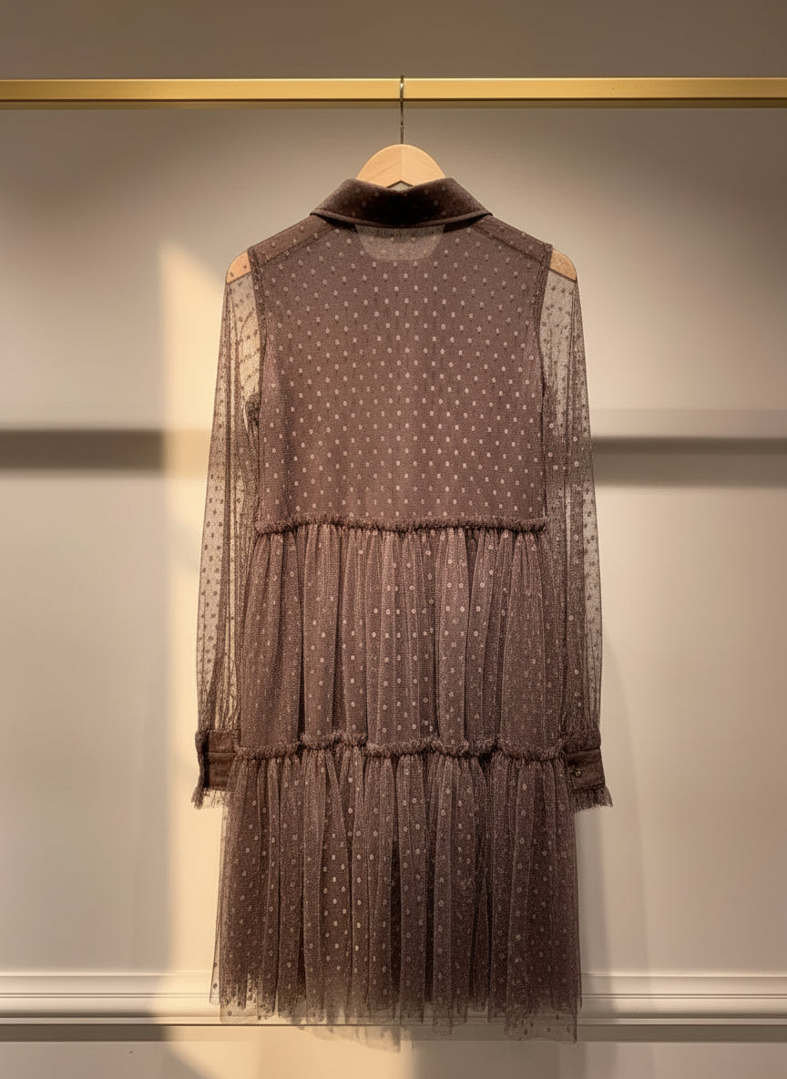 Brown polka dot dress with sheer overlay on a hanger against a neutral background